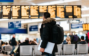 Man checking departures and arrivals board Man looking at a departures and arrivals board